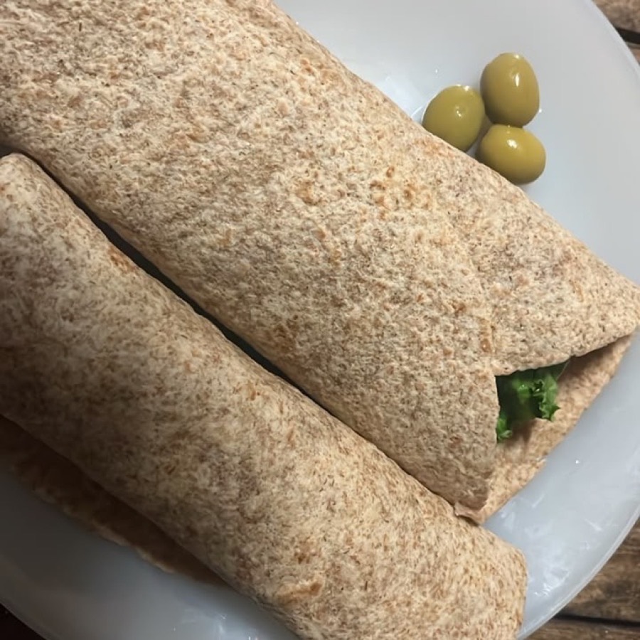 Deux wraps au blé complet garnis de salade, servis avec des olives